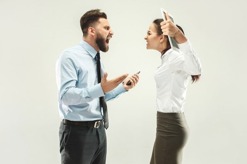 Un hombre y una mujer discutiendo por un delito contra las personas e intereses colectivos